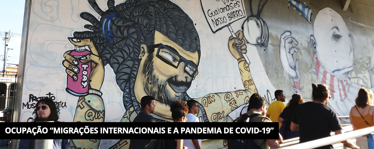 Colorida mostrando grafites em paredes e dez pessoas em fila. Tarja preta com Ocupação "Migrações Internacionais e a pandemia de COVID-19" escrito em branco