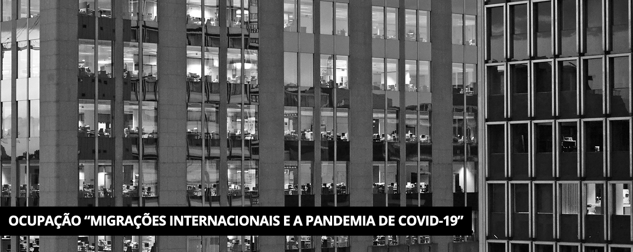 Em preto e branco com fachada de dois prédios, várias janelas e, atrás, pessoas trabalhando. Tarja preta com Ocupação "Migrações Internacionais e a pandemia de COVID-19" escrito em branco